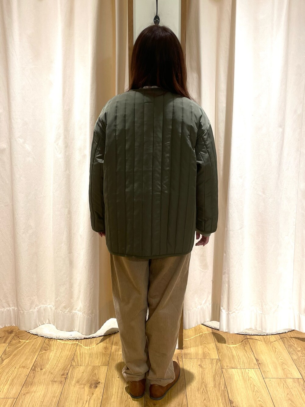 ホワイト系のシャツ/ブラウス、グリーン系のニット/セーター、グリーン系のノーカラージャケットを着用したレディースの冬コーディネートの3枚目の写真