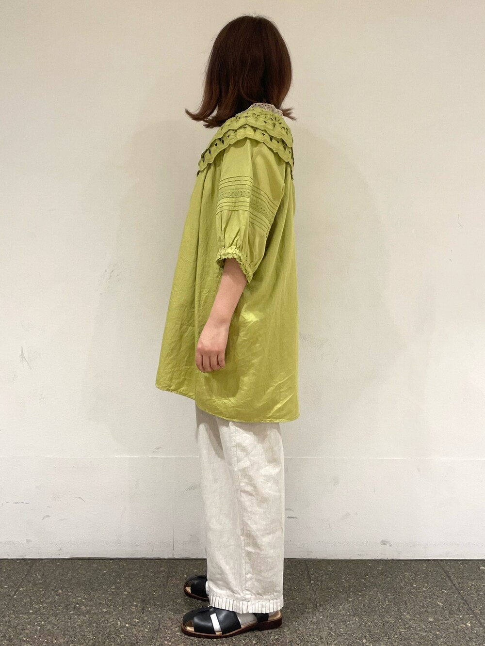 ベージュ系のタンクトップ、グリーン系のチュニック、ホワイト系のその他パンツを着用したレディースの夏コーディネートの3枚目の写真