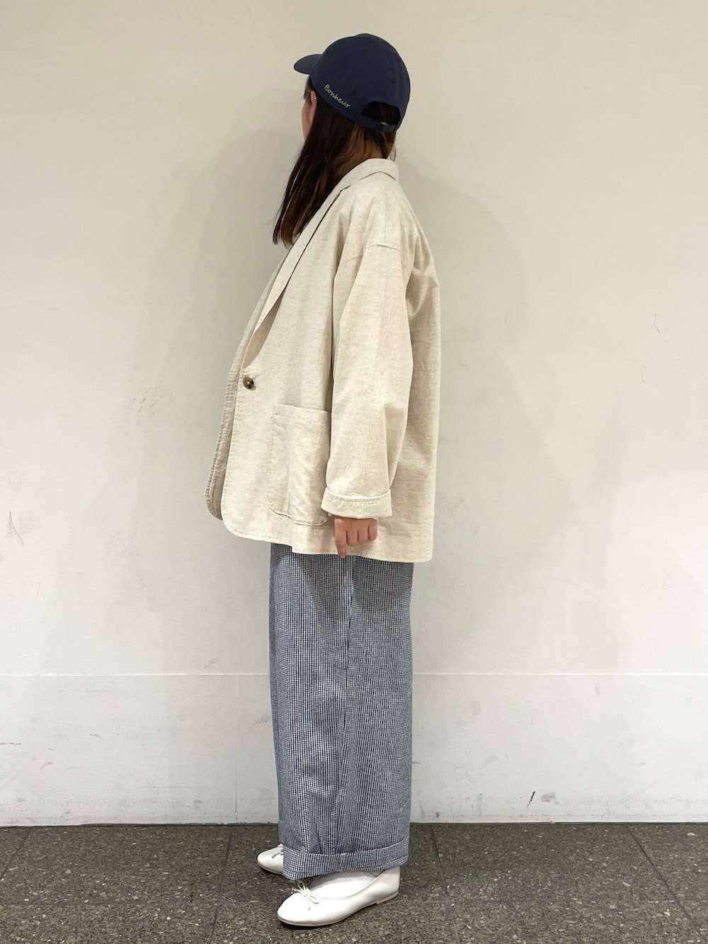 ホワイト系のパンプス、ホワイト系のシャツ/ブラウス、ベージュ系のベストを着用したレディースの春コーディネートの3枚目の写真