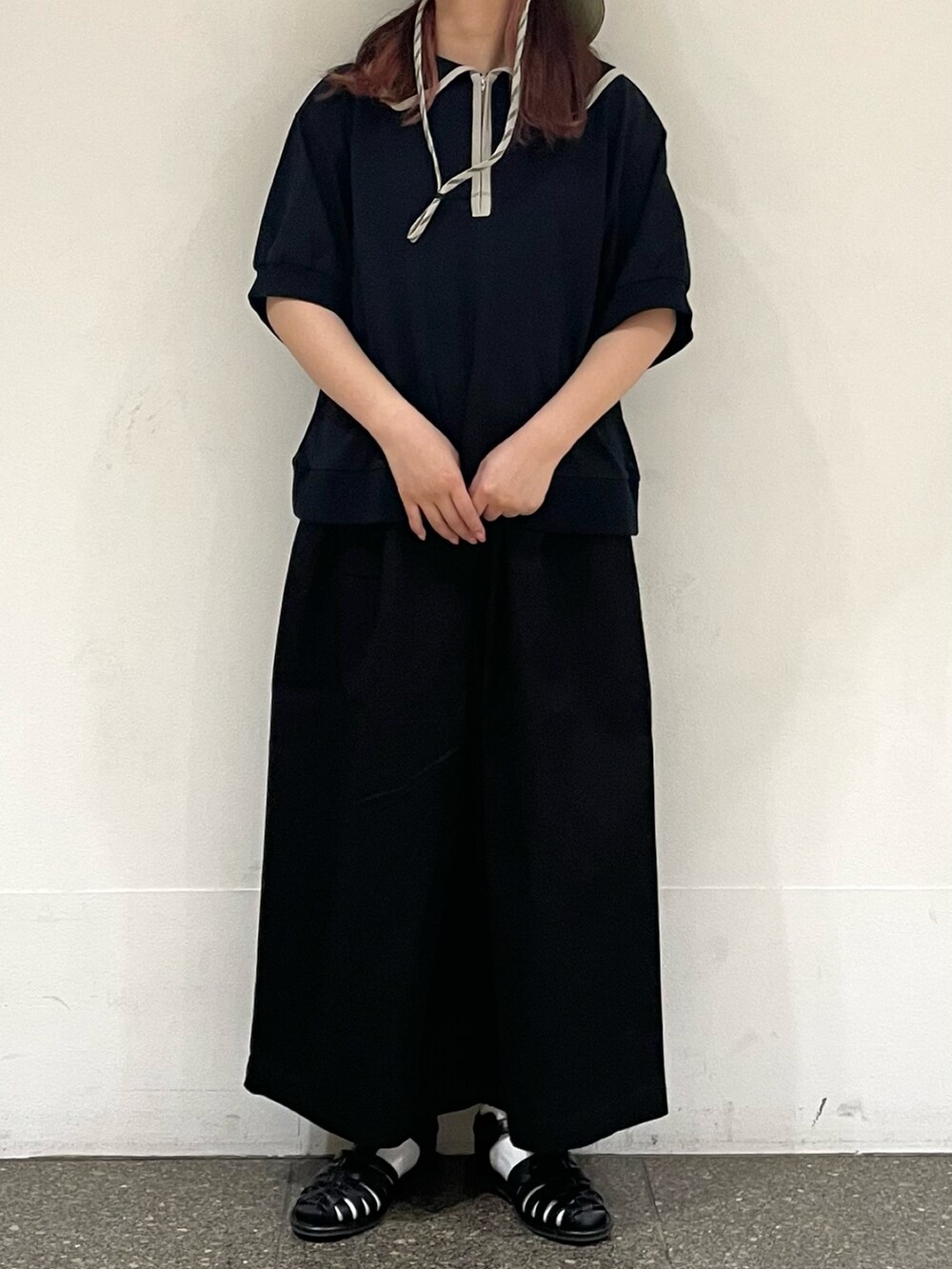 ブラック系のサンダル、ブラック系のTシャツ/カットソー、ブラック系のその他パンツを着用したレディースの夏コーディネートの2枚目の写真