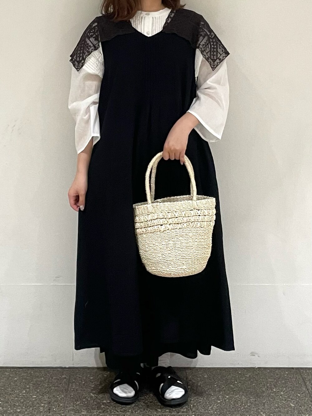 ホワイト系のシャツ/ブラウス、ブラック系のワンピース、ホワイト系のハンドバッグを着用したレディースの夏コーディネートの2枚目の写真