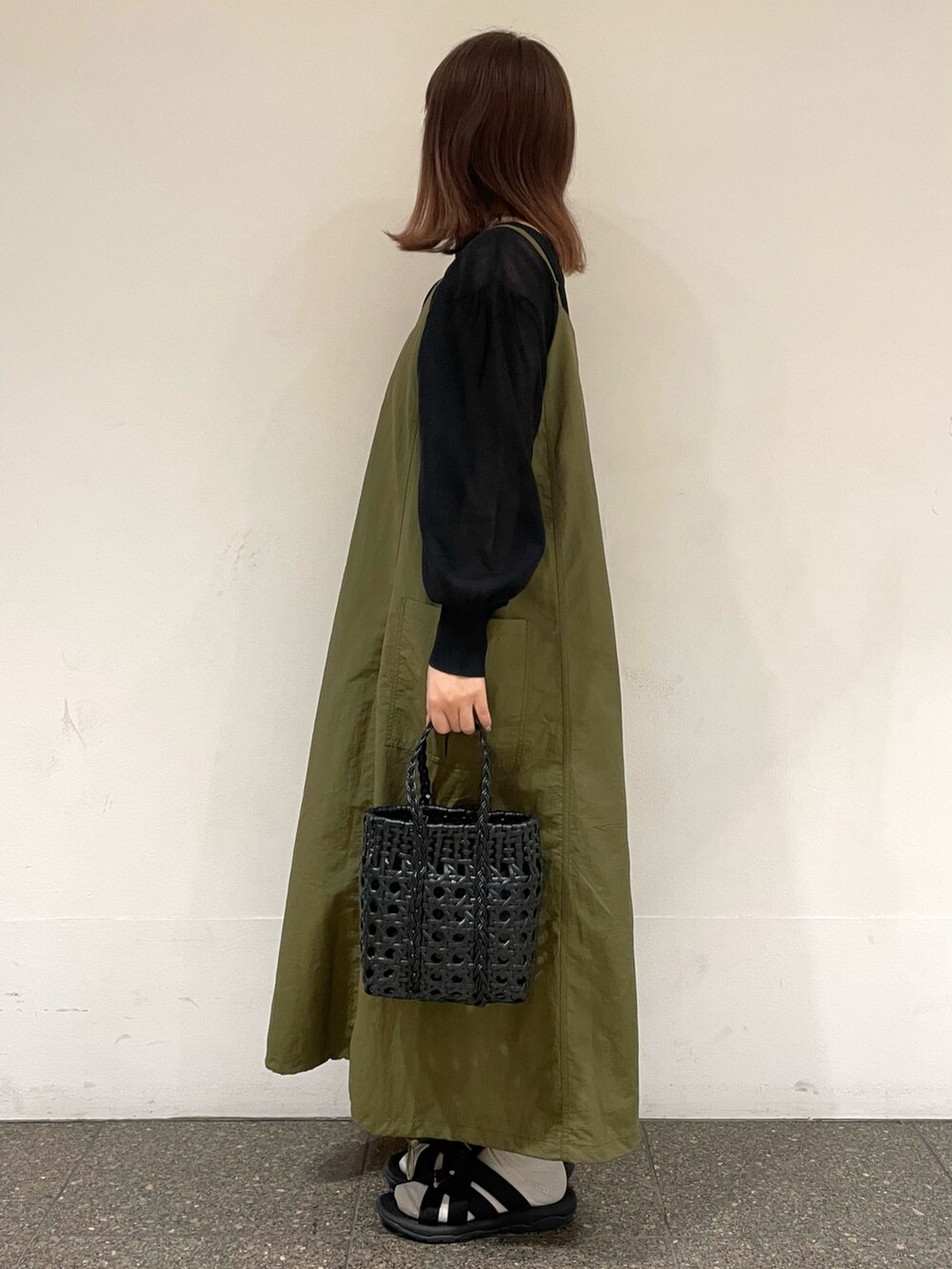 ブラック系のカーディガン/ボレロ、グリーン系のワンピース、グレー系のハンドバッグを着用したレディースの夏コーディネートの3枚目の写真