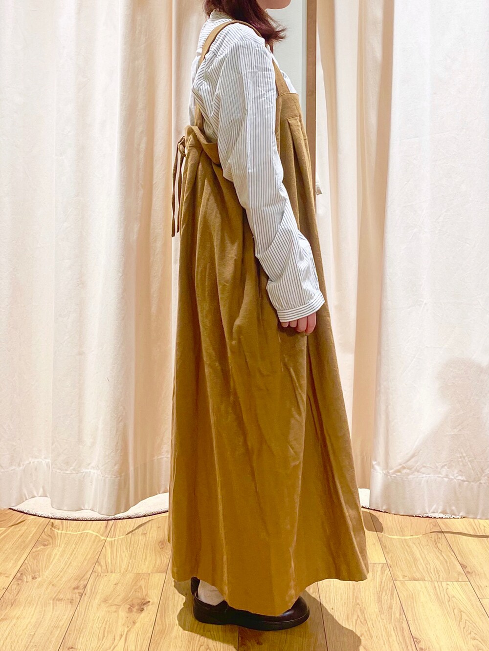 ホワイト系のシャツ/ブラウス、イエロー系のジャンパースカート、ブラウン系のサンダルを着用したレディースの秋コーディネートの4枚目の写真