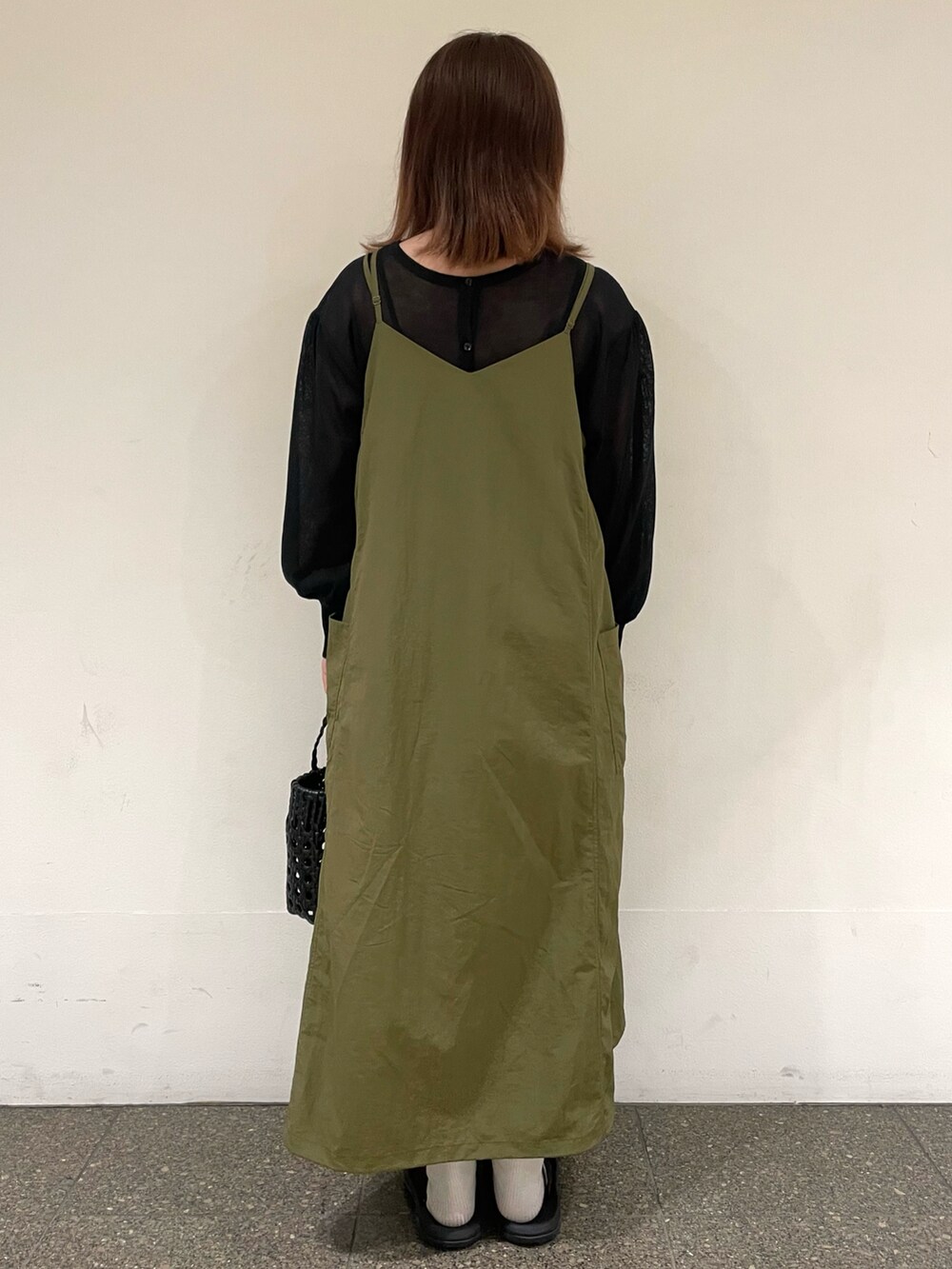 ブラック系のカーディガン/ボレロ、グリーン系のワンピース、グレー系のハンドバッグを着用したレディースの夏コーディネートの4枚目の写真