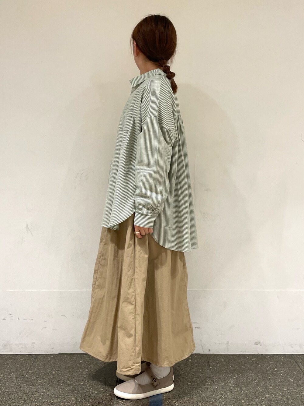 ホワイト系のTシャツ/カットソー、グリーン系のシャツ/ブラウス、ブラウン系のスニーカーを着用したレディースの秋コーディネートの3枚目の写真