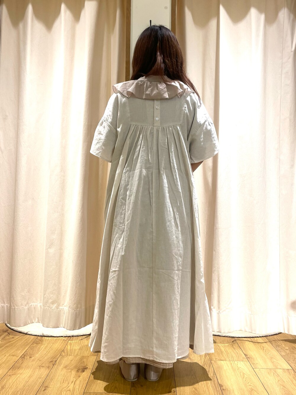 ホワイト系のワンピース、ベージュ系のスカート、ベージュ系のトートバッグを着用したレディースの夏コーディネートの3枚目の写真