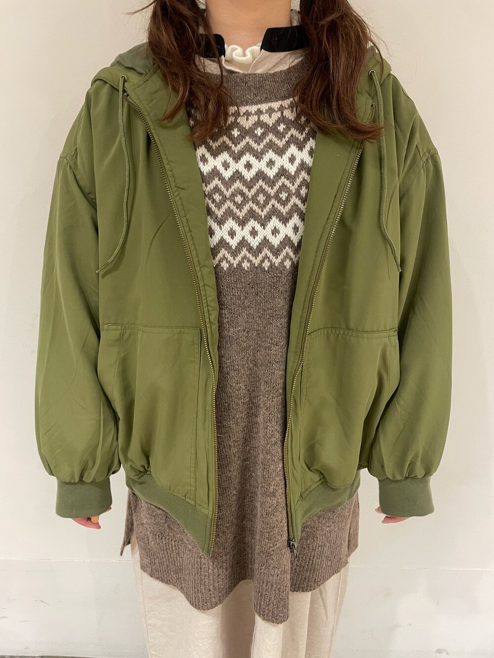 ベージュ系のワンピース、グリーン系のブルゾン、ブラウン系のベストを着用したレディースの冬コーディネートの4枚目の写真