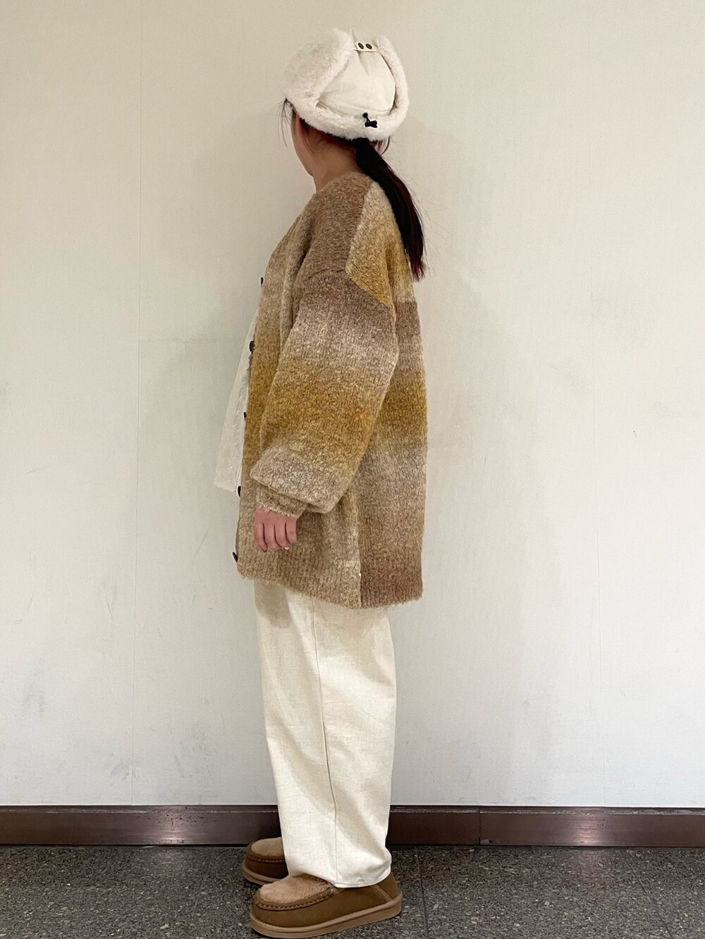 イエロー系のその他シューズ、ホワイト系のハットを着用したレディースの冬コーディネートの3枚目の写真