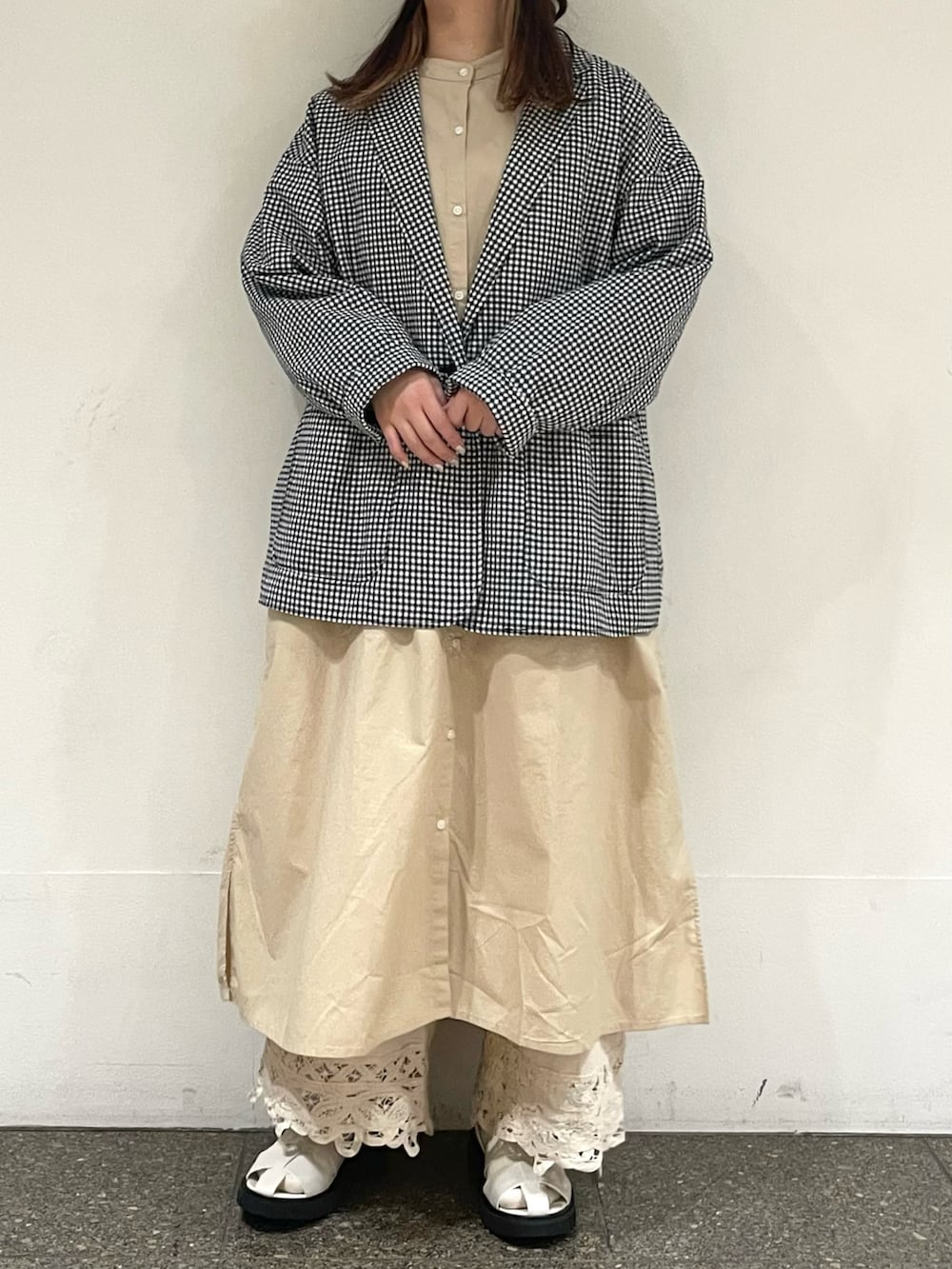 ベージュ系のワンピース、ブラック系のノーカラージャケット、ホワイト系のその他パンツを着用したレディースの春コーディネートの2枚目の写真