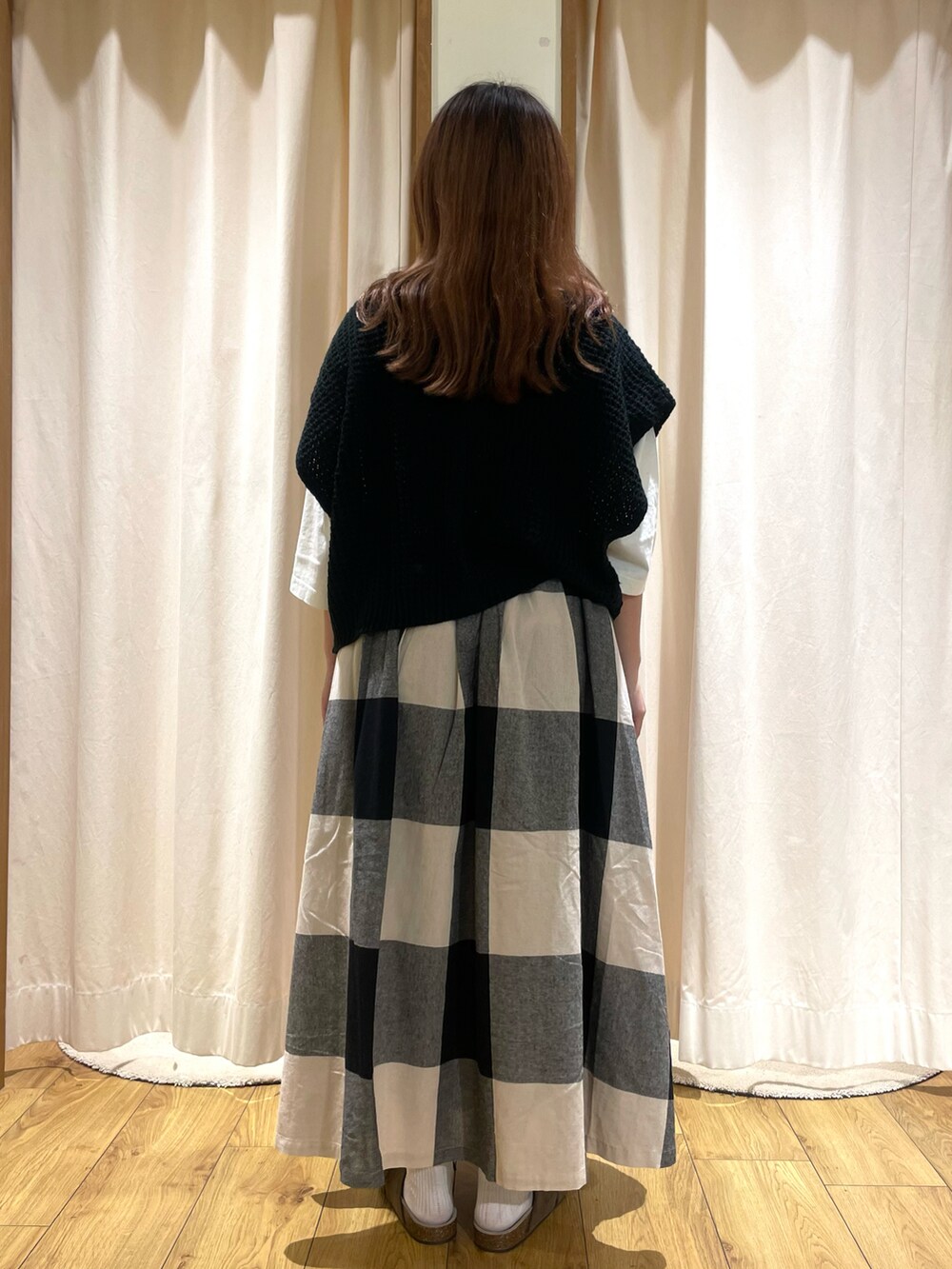 ホワイト系のTシャツ/カットソー、ブラック系のベスト、ブラック系のスカートを着用したレディースの夏コーディネートの3枚目の写真