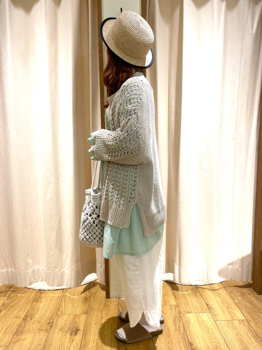 イエロー系のサンダル、ホワイト系のカーディガン/ボレロ、グリーン系のチュニックを着用したレディースの夏コーディネートの3枚目の写真