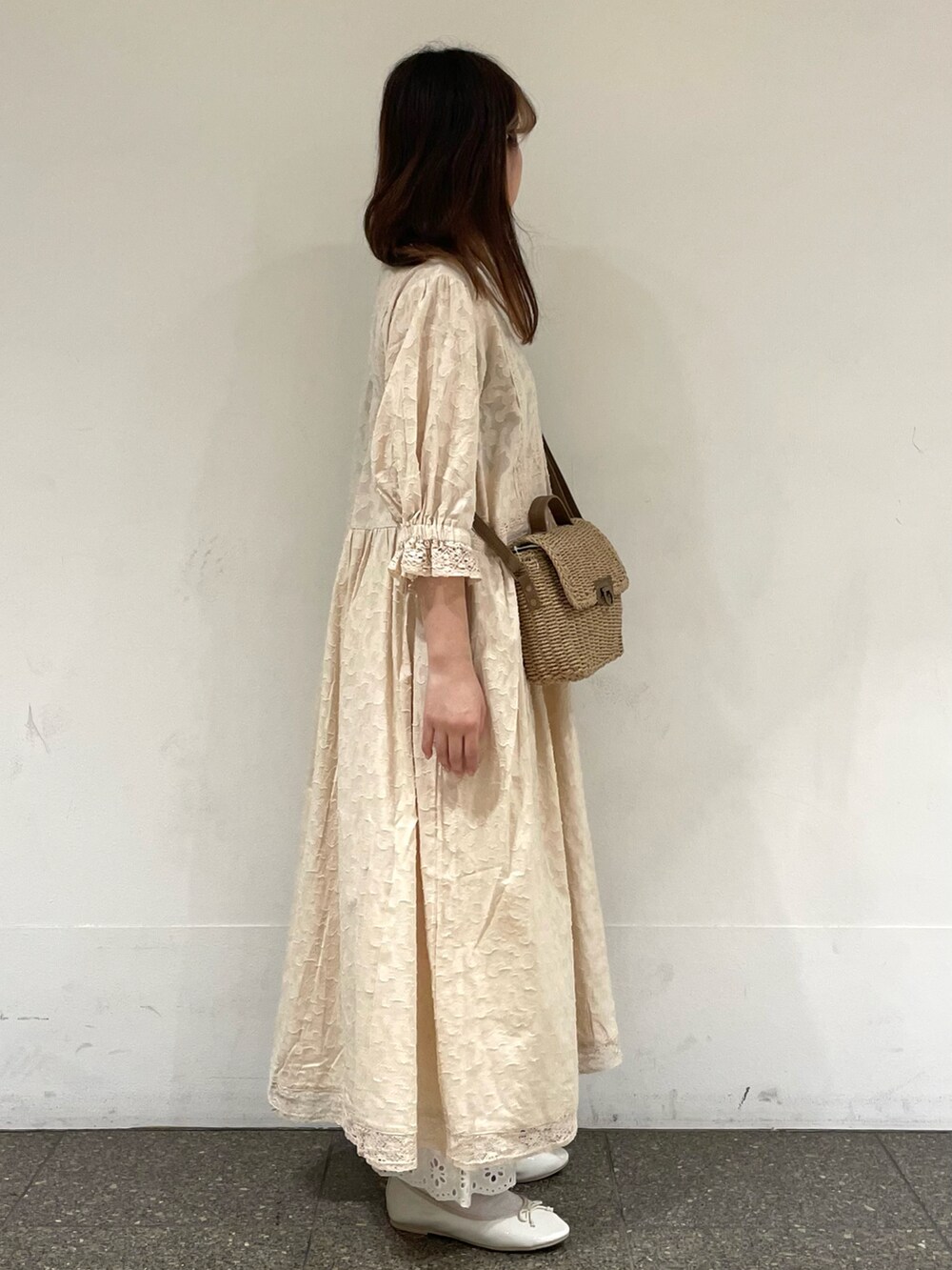 ホワイト系のパンプス、ホワイト系のワンピース、ベージュ系のハンドバッグを着用したレディースの春コーディネートの5枚目の写真