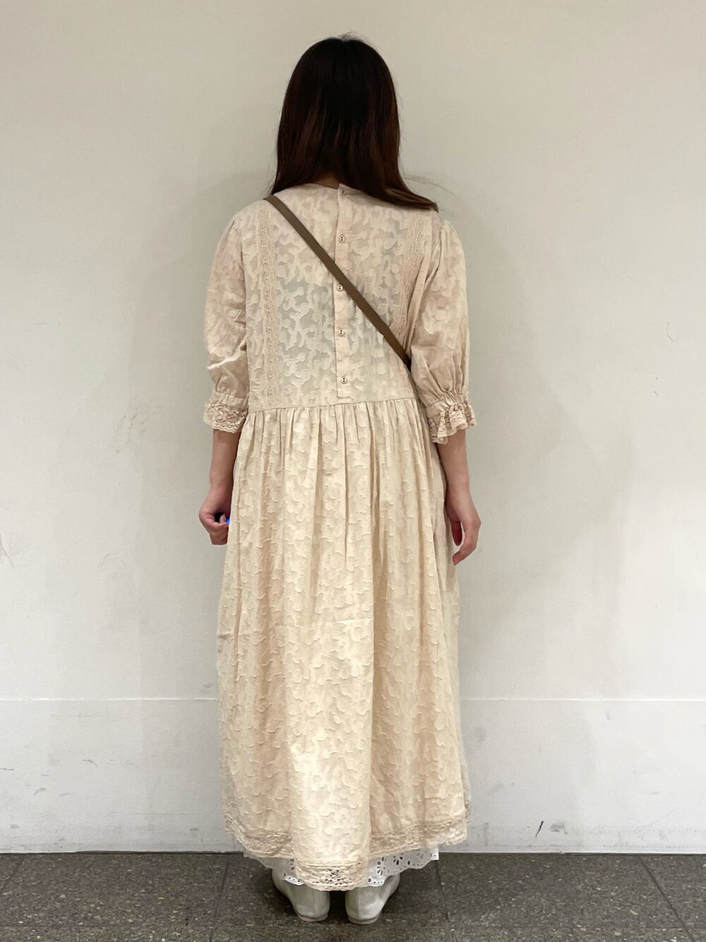 ホワイト系のパンプス、ホワイト系のワンピース、ベージュ系のハンドバッグを着用したレディースの春コーディネートの4枚目の写真