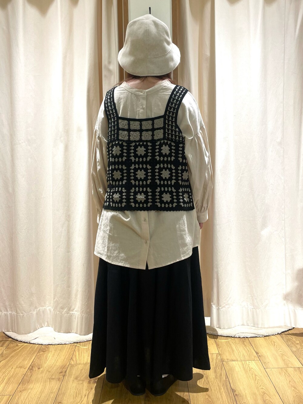 ベージュ系のチュニック、ブラック系のベスト、ブラック系のスカートを着用したレディースの秋コーディネートの3枚目の写真