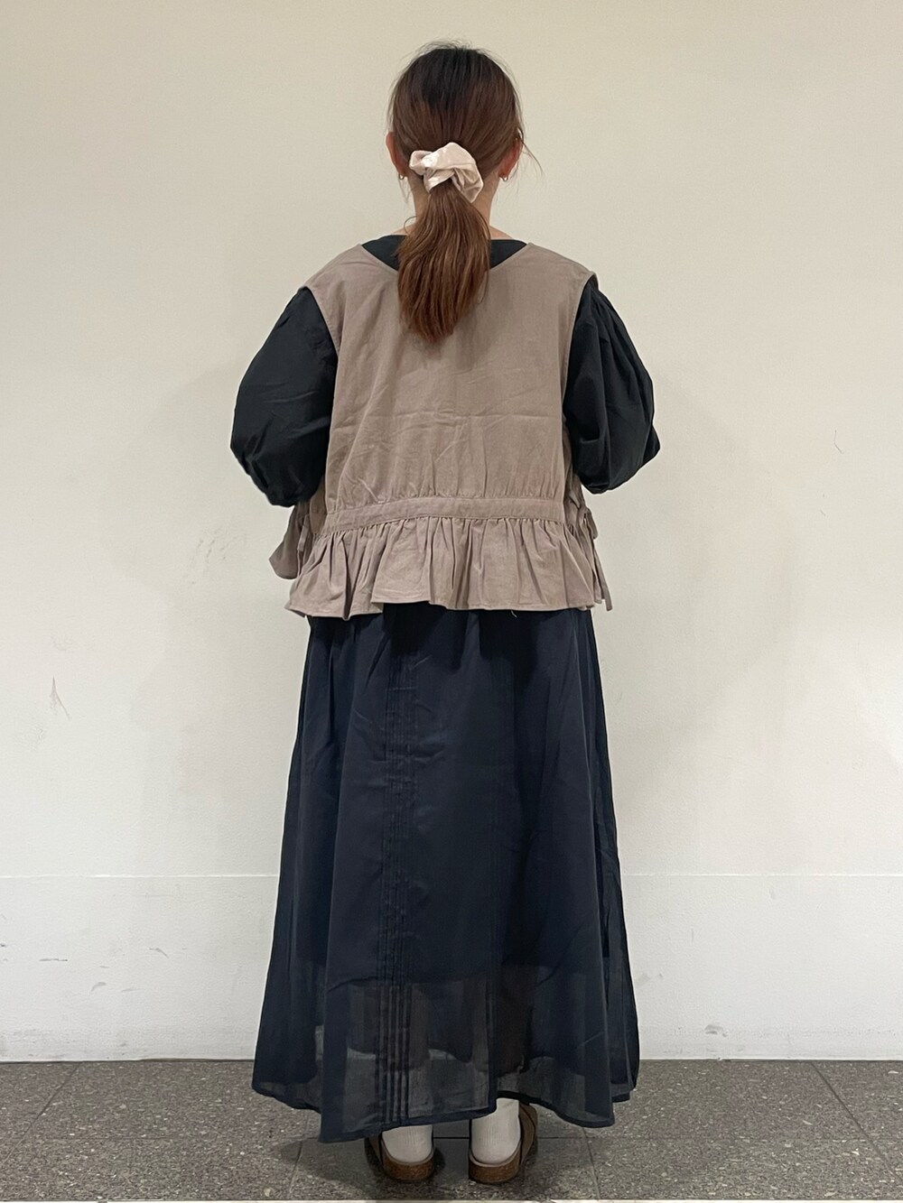 ブラック系のシャツ/ブラウス、ベージュ系のベスト、ブラック系のスカートを着用したレディースの夏コーディネートの3枚目の写真