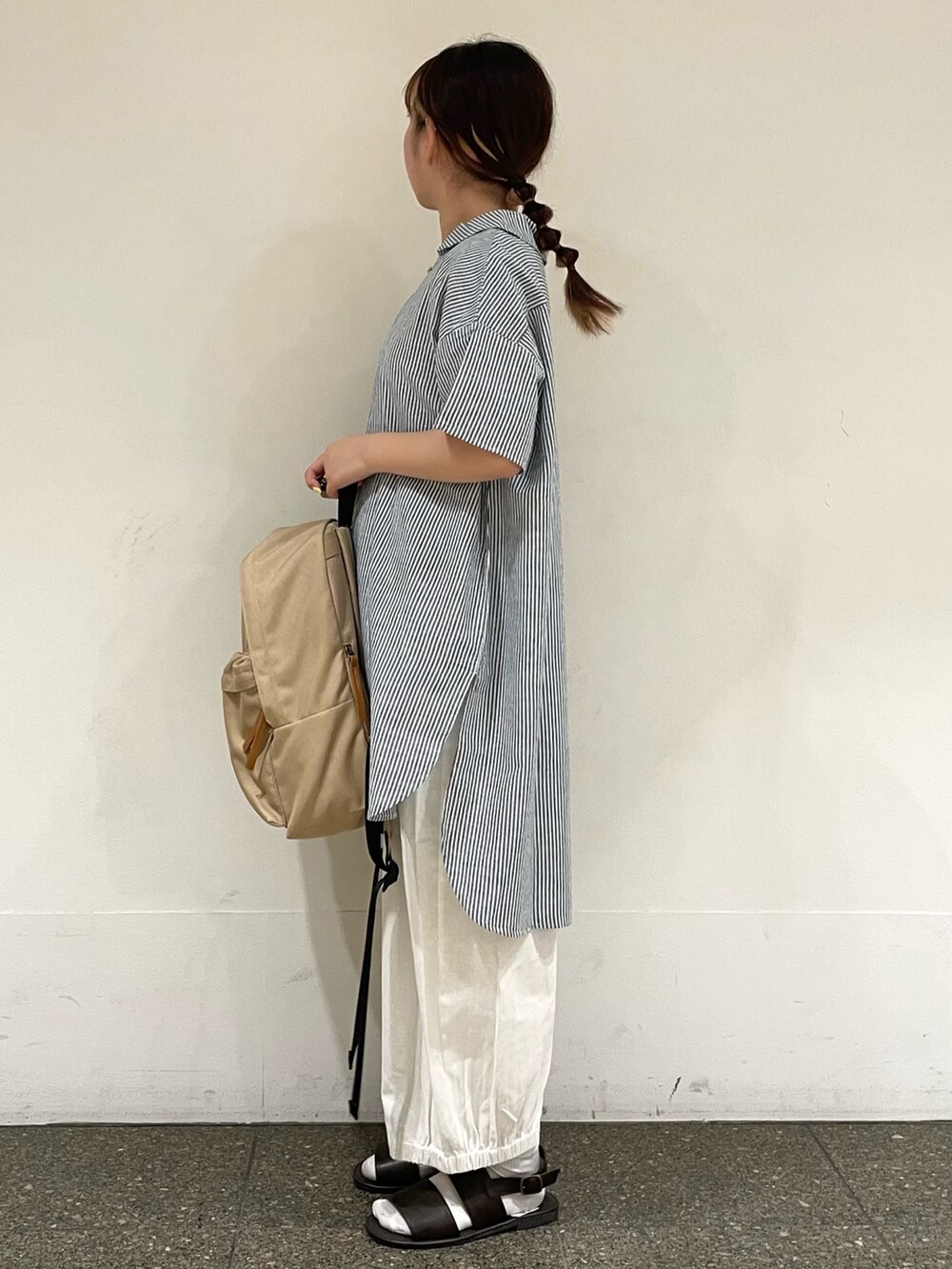 ブラウン系のサンダル、ホワイト系のその他パンツ、ベージュ系のハンドバッグを着用したレディースの秋コーディネートの3枚目の写真