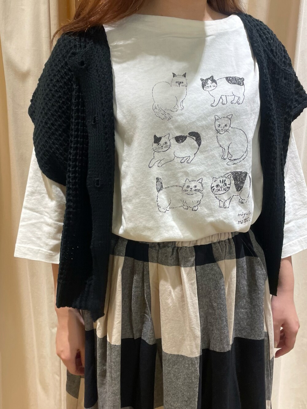 ホワイト系のTシャツ/カットソー、ブラック系のベスト、ブラック系のスカートを着用したレディースの夏コーディネートの4枚目の写真