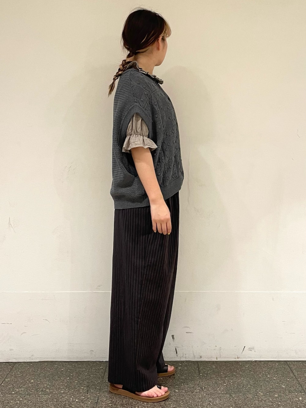 ブラウン系のサンダル、ベージュ系のシャツ/ブラウス、グレー系のベストを着用したレディースの秋コーディネートの5枚目の写真