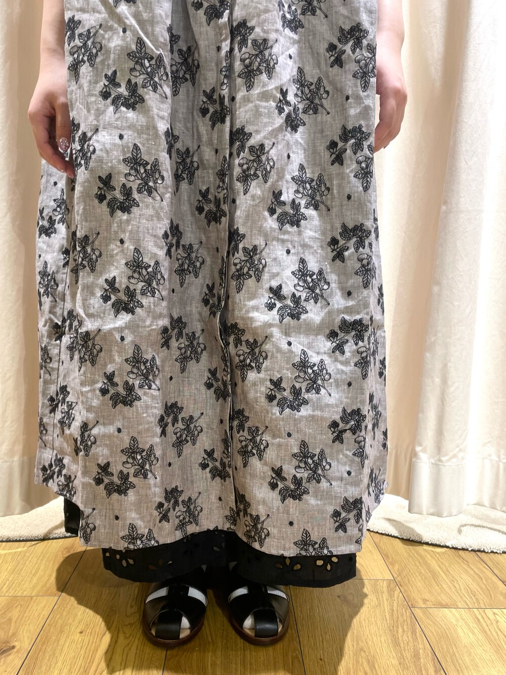 グレー系のワンピース、ブラック系のスカート、ブラック系のサンダルを着用したレディースの春コーディネートの5枚目の写真