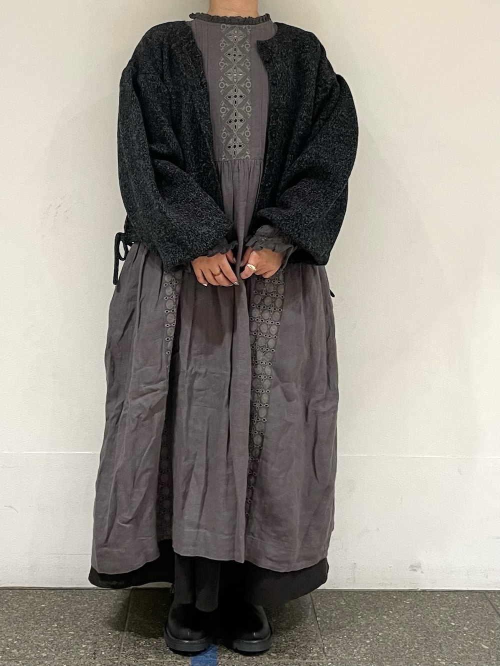 ブラック系のカーディガン/ボレロ、グレー系のスカート、ブラック系のサンダルを着用したレディースの秋コーディネートの2枚目の写真