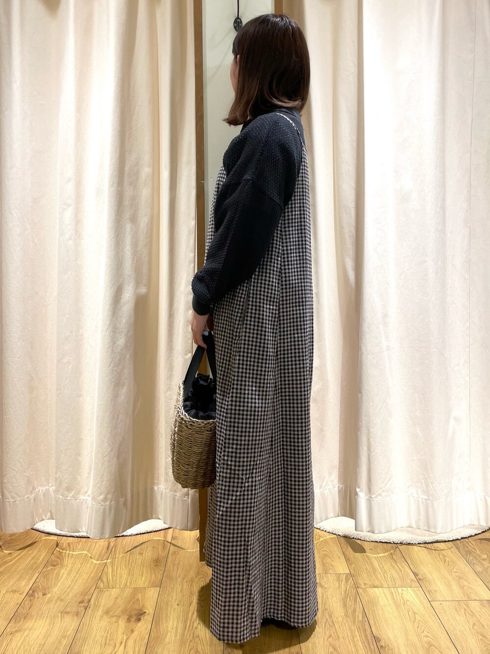 グレー系のカーディガン/ボレロ、ブラック系のワンピース、ブラック系のハンドバッグを着用したレディースの春コーディネートの2枚目の写真