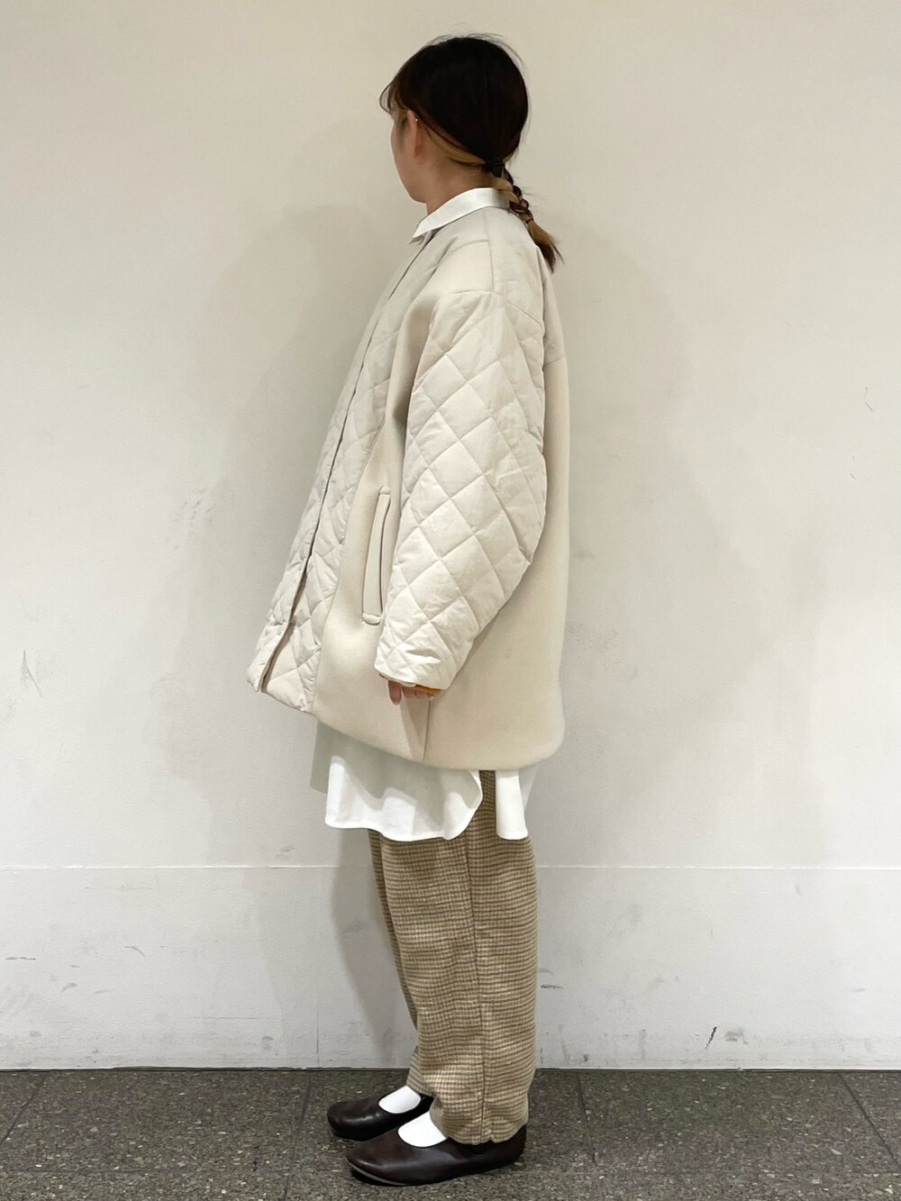 ブラウン系のドレスシューズ、ホワイト系のチュニック、ホワイト系のブルゾンを着用したレディースの冬コーディネートの3枚目の写真