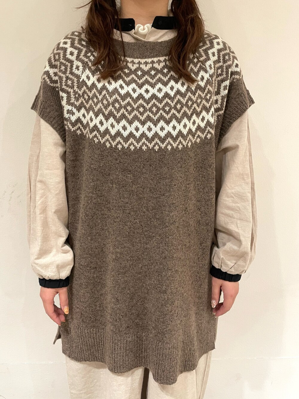 ベージュ系のワンピース、ブラウン系のベスト、ブラウン系のその他パンツを着用したレディースの冬コーディネートの4枚目の写真