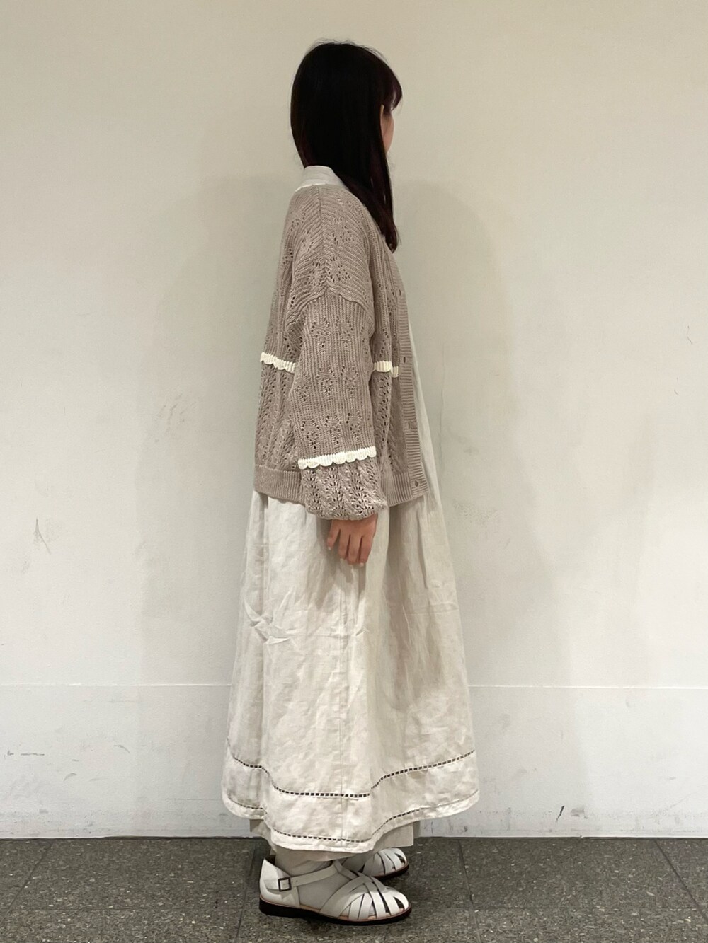 ホワイト系のサンダル、ベージュ系のカーディガン/ボレロ、グレー系のワンピースを着用したレディースの春コーディネートの5枚目の写真