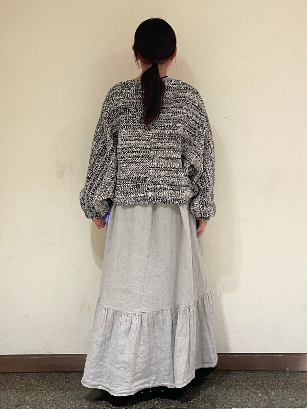 グレー系のワンピース、グレー系のドレスシューズ、ブラック系のカーディガン/ボレロを着用したレディースの冬コーディネートの4枚目の写真