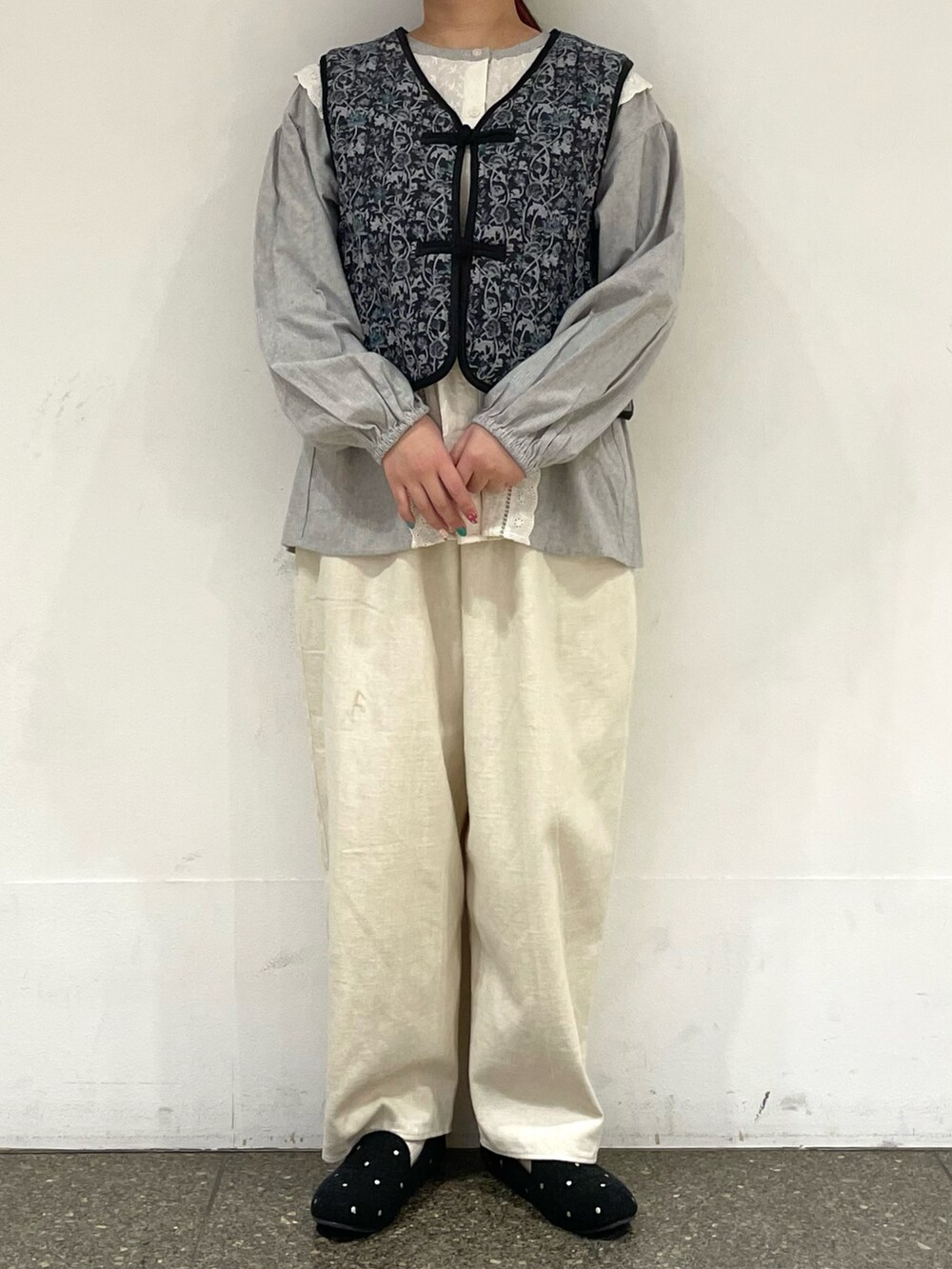 グレー系のドレスシューズ、グレー系のベストを着用したレディースの冬コーディネートの2枚目の写真