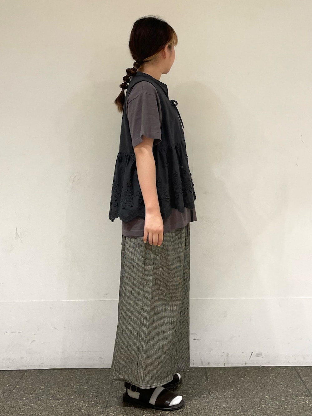 ブラウン系のサンダル、ブラウン系のTシャツ/カットソー、グレー系のベストを着用したレディースの秋コーディネートの5枚目の写真