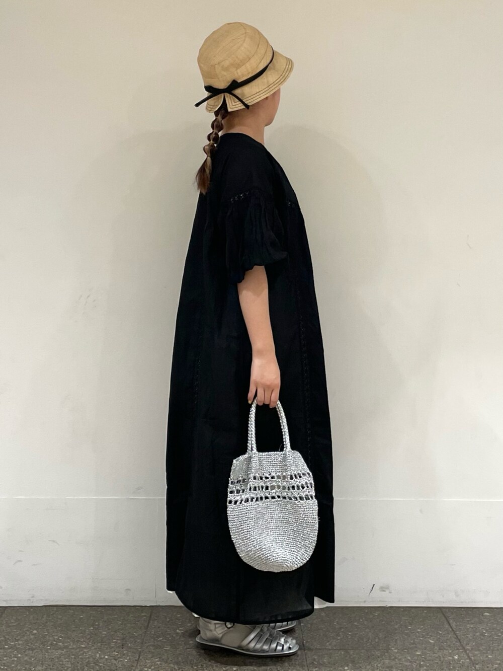 シルバー系のサンダル、ブラック系のワンピース、シルバー系のハンドバッグを着用したレディースの夏コーディネートの5枚目の写真