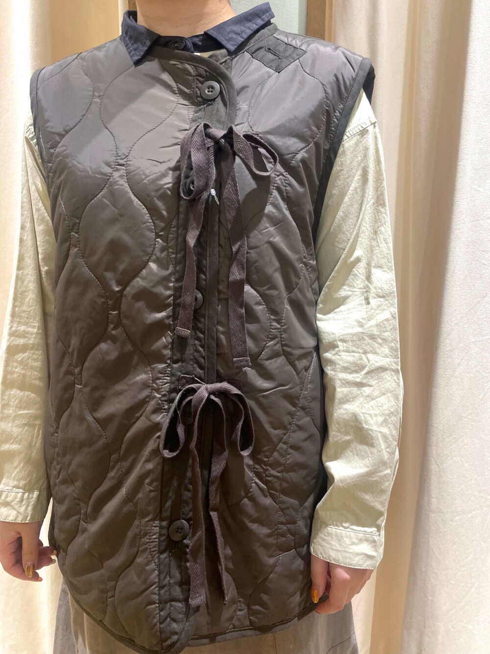 ベージュ系のシャツ/ブラウス、ブルー系のベスト、グレー系のその他パンツを着用したレディースの秋コーディネートの4枚目の写真