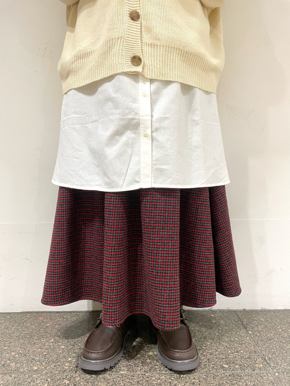 レッド系のスカート、ブラウン系のブーツ、ホワイト系のチュニックを着用したレディースの冬コーディネートの5枚目の写真