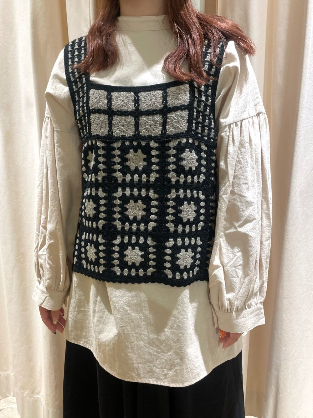 ベージュ系のチュニック、ブラック系のベスト、ブラック系のスカートを着用したレディースの秋コーディネートの4枚目の写真