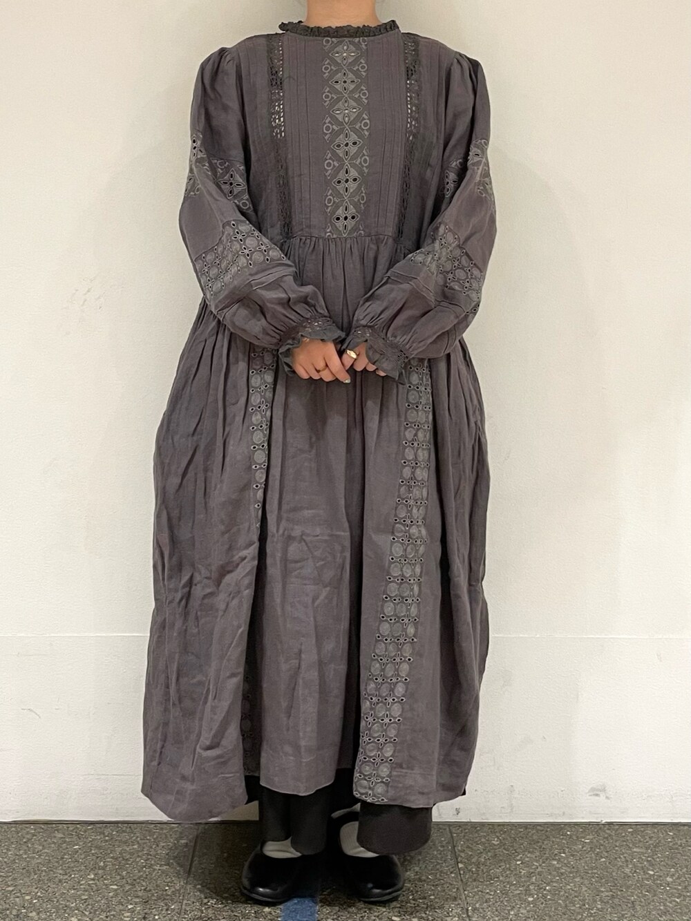 グレー系のスカート、ブラック系のドレスシューズ、グレー系のワンピースを着用したレディースの秋コーディネートの2枚目の写真