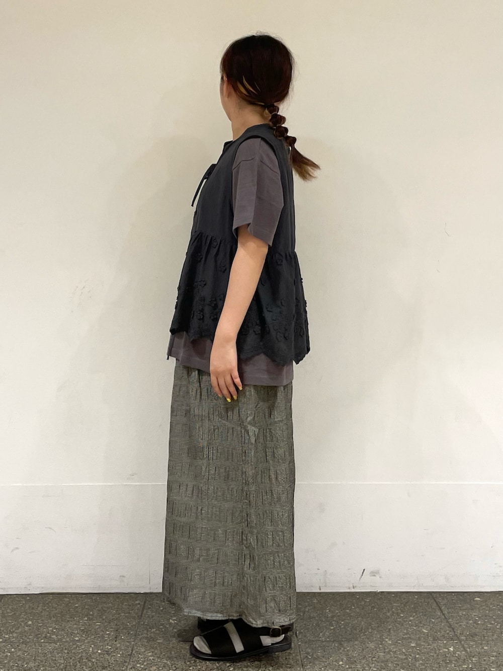 ブラウン系のサンダル、ブラウン系のTシャツ/カットソー、グレー系のベストを着用したレディースの秋コーディネートの3枚目の写真