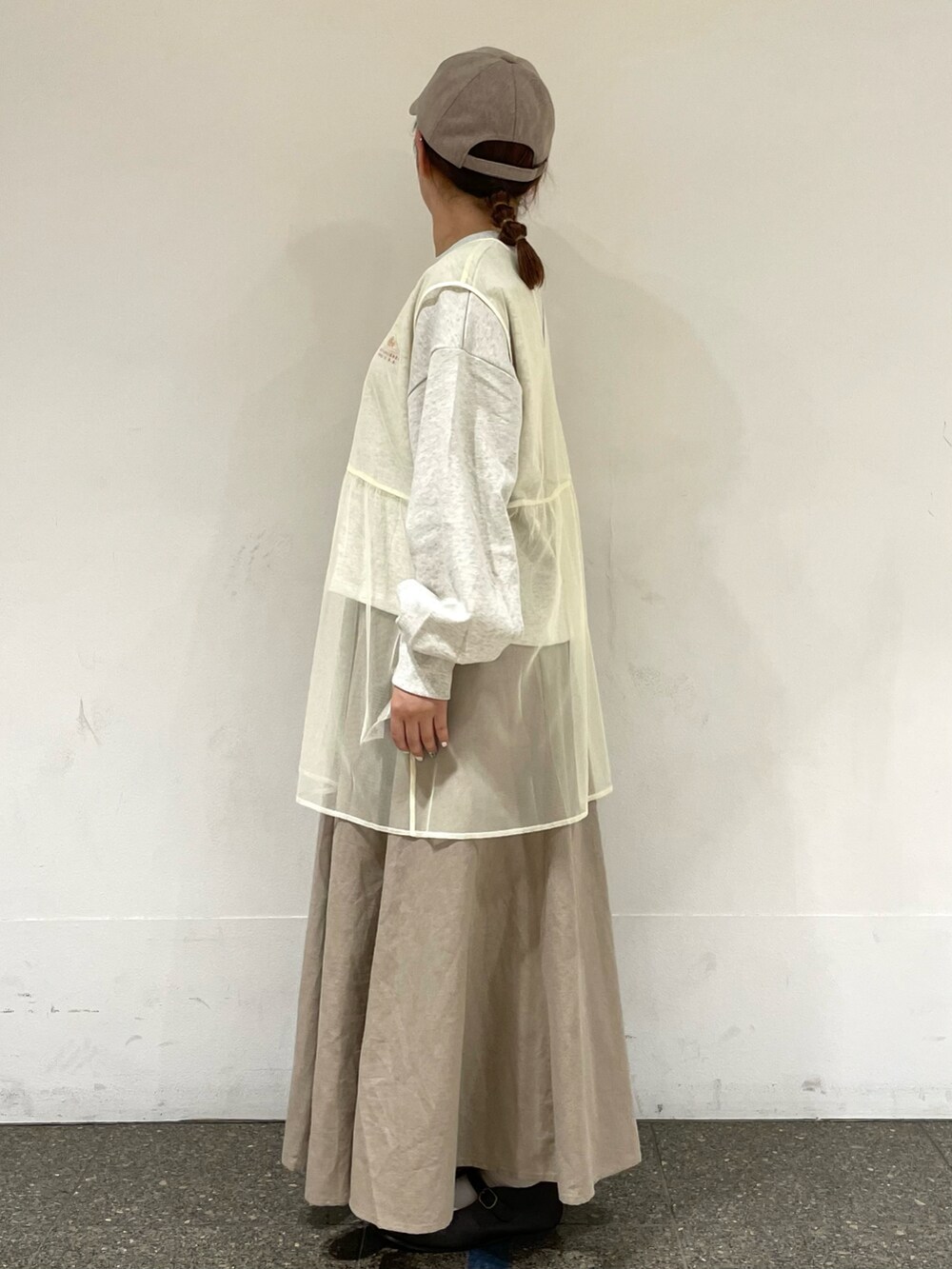 グレー系のTシャツ/カットソー、ホワイト系のベスト、ベージュ系のスカートを着用したレディースの秋コーディネートの3枚目の写真