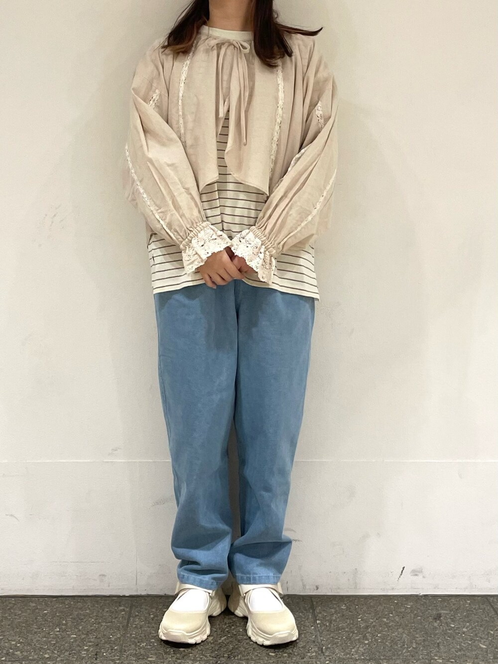 ベージュ系のスニーカー、ベージュ系のシャツ/ブラウス、ベージュ系のTシャツ/カットソーを着用したレディースの春コーディネートの2枚目の写真