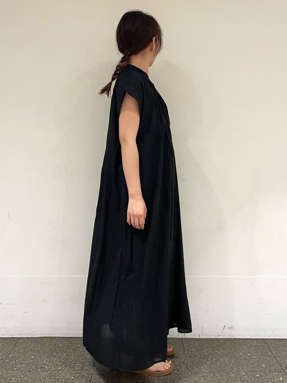 ブラウン系のサンダル、ブラック系のワンピースを着用したレディースの秋コーディネートの5枚目の写真