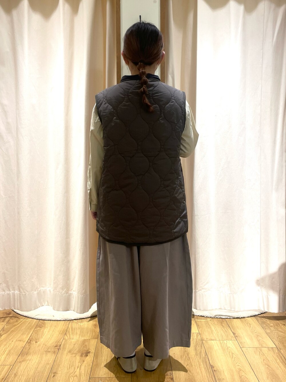 ベージュ系のシャツ/ブラウス、ブルー系のベスト、グレー系のその他パンツを着用したレディースの秋コーディネートの3枚目の写真