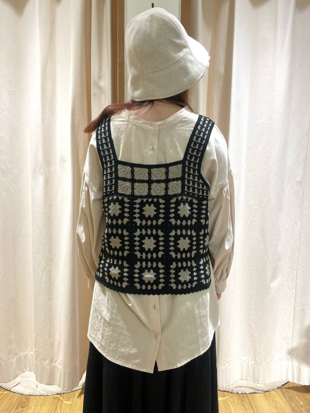 ベージュ系のチュニック、ブラック系のベスト、ブラック系のスカートを着用したレディースの秋コーディネートの5枚目の写真