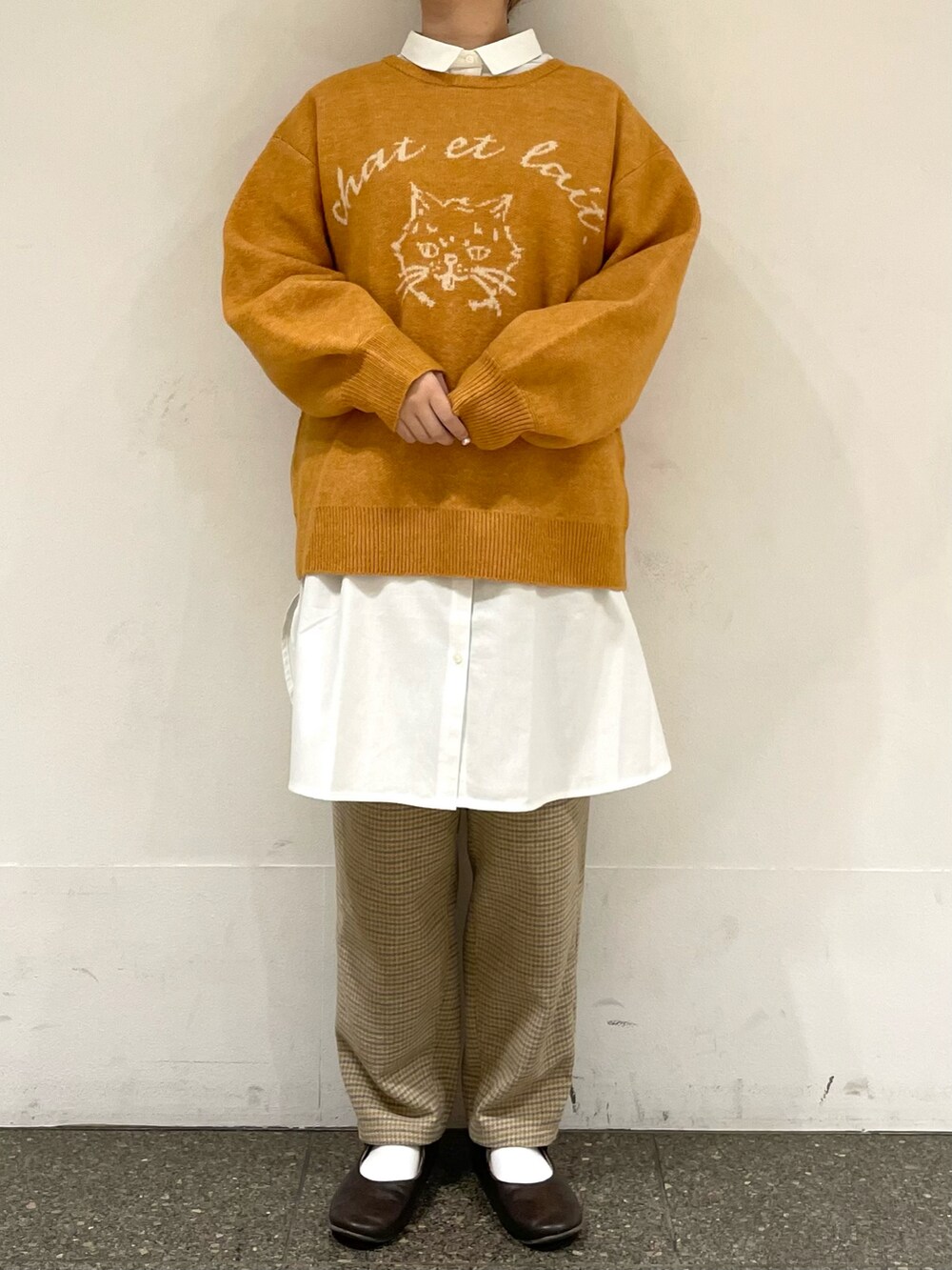 ホワイト系のチュニック、イエロー系のニット/セーター、グレー系のその他パンツを着用したレディースの冬コーディネートの2枚目の写真