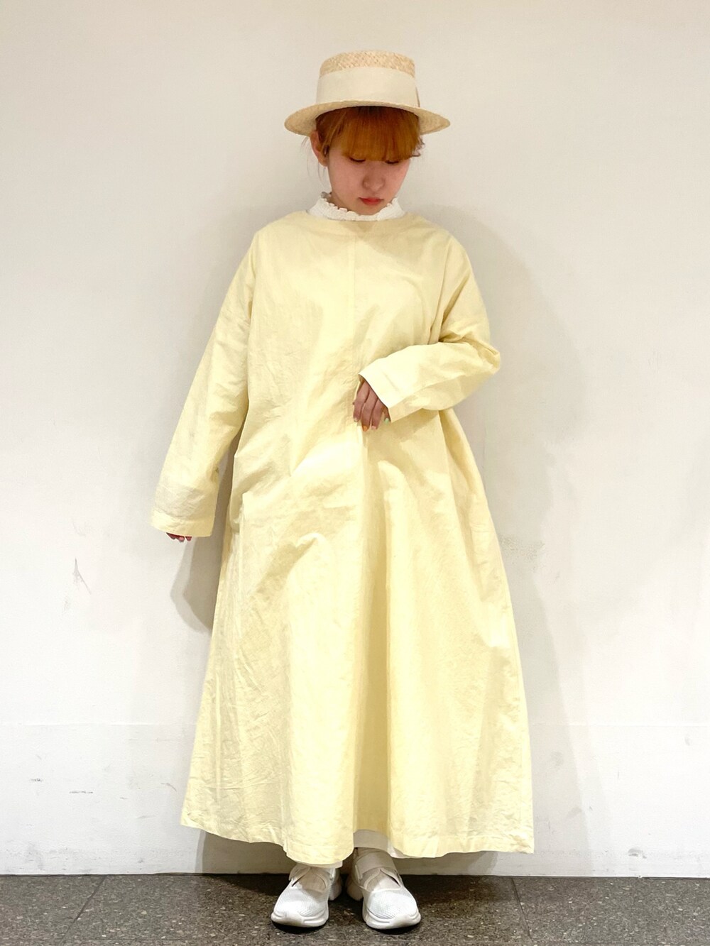 ホワイト系のシューズ、ホワイト系のスカート、イエロー系のワンピースを着用したレディースの春コーディネートの2枚目の写真