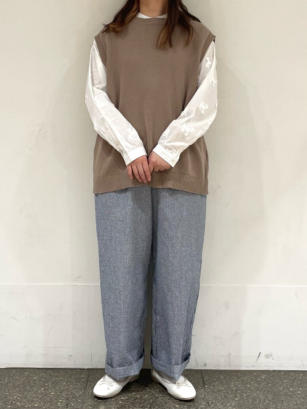 ホワイト系のシャツ/ブラウス、ベージュ系のベスト、ブルー系のその他パンツを着用したレディースの春コーディネートの2枚目の写真