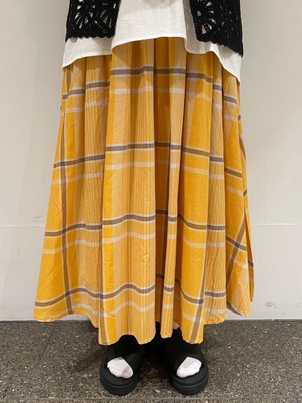 ブラック系のサンダル、ホワイト系のかごバッグ、ホワイト系のTシャツ/カットソーを着用したレディースの夏コーディネートの5枚目の写真