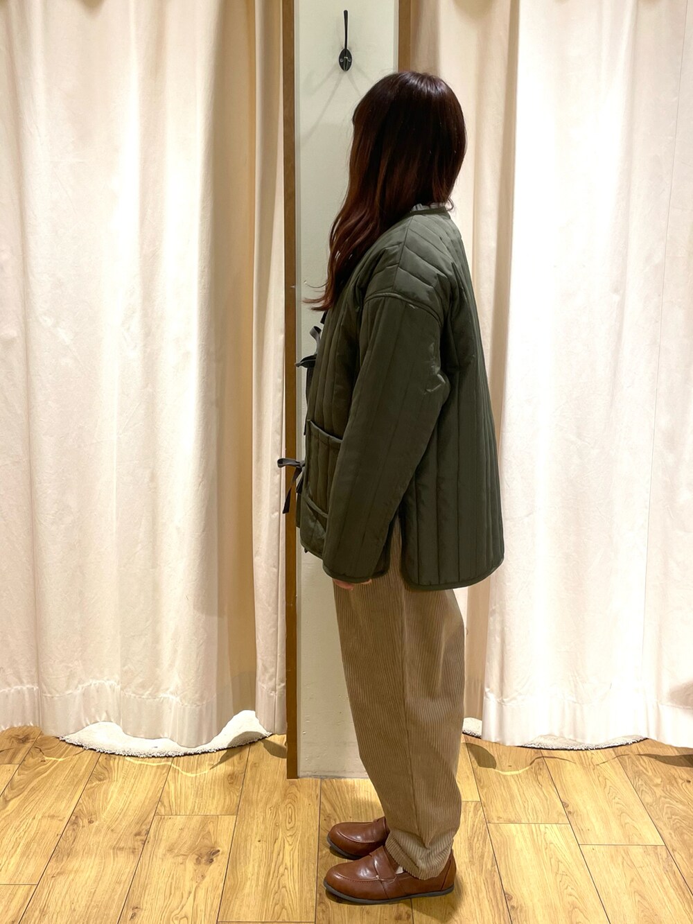 ホワイト系のシャツ/ブラウス、グリーン系のニット/セーター、グリーン系のノーカラージャケットを着用したレディースの冬コーディネートの2枚目の写真
