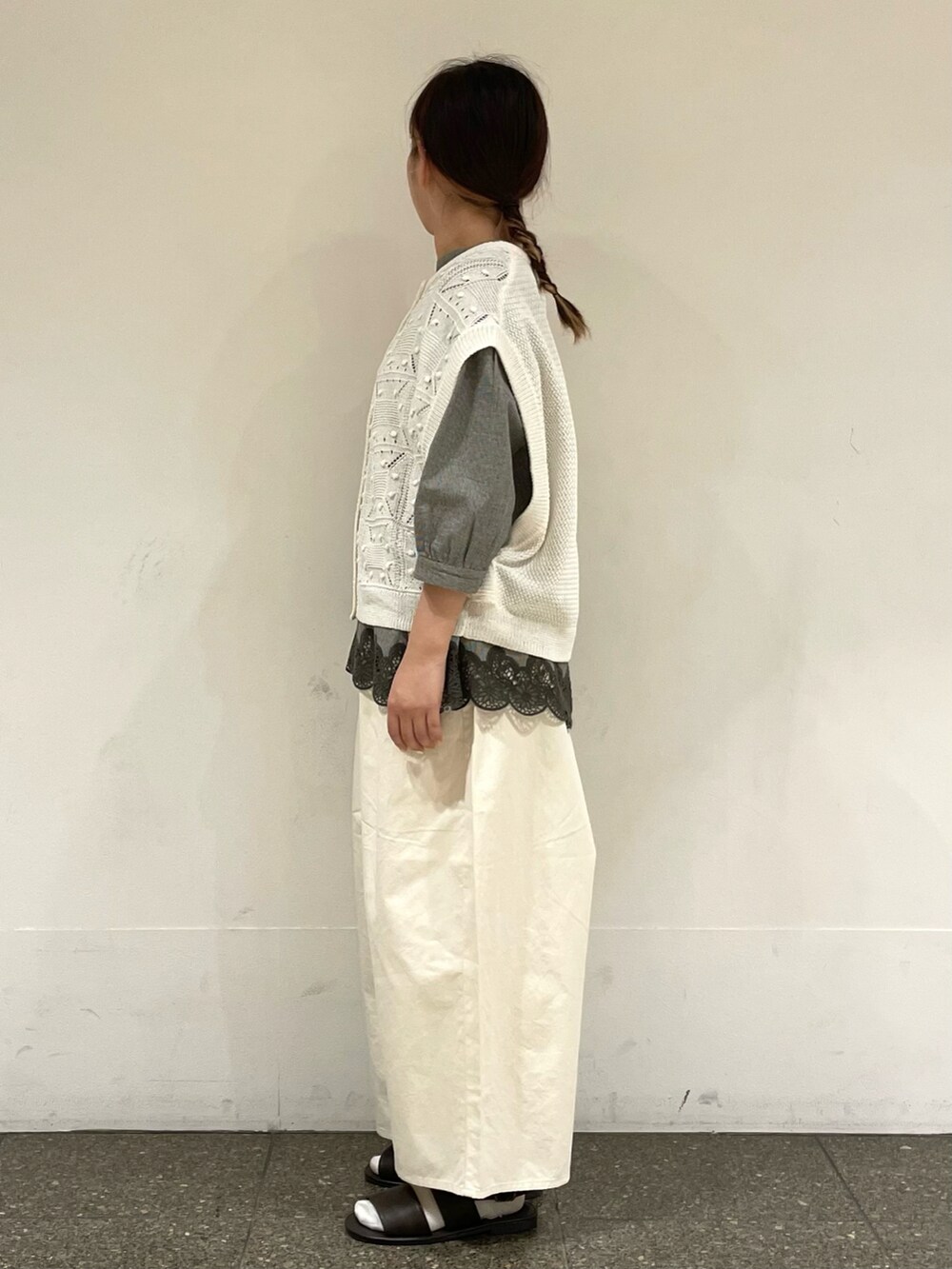 ブラウン系のサンダル、グレー系のシャツ/ブラウス、ホワイト系のベストを着用したレディースの夏コーディネートの3枚目の写真