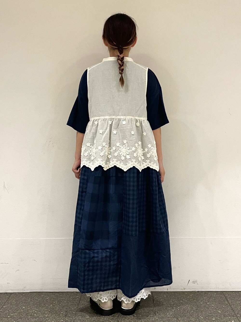 ホワイト系のサンダル、ホワイト系のベスト、ブルー系のワンピースを着用したレディースの秋コーディネートの4枚目の写真