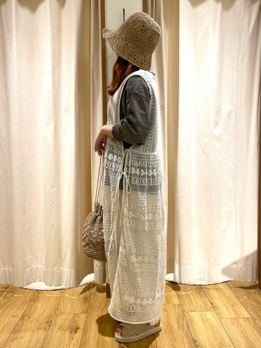 ベージュ系のエコバッグ/サブバッグ、ホワイト系のワンピース、ベージュ系のサンダルを着用したレディースの春コーディネートの3枚目の写真